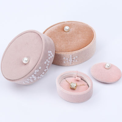 Une petite boîte à bagues en velours ovale, une boîte à bagues en perles.
